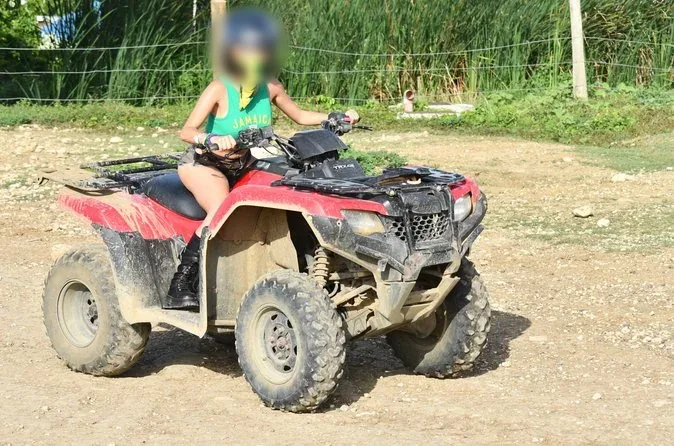 An ATV rider in a full-face helmet on a dirt track